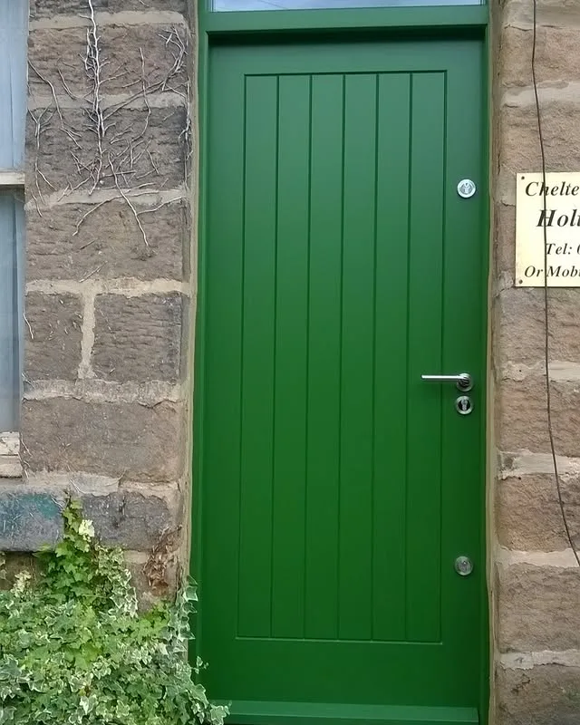 Green made-to-measure timber exterior door fitted into a stone property